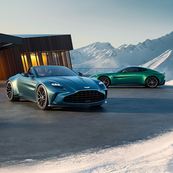 Two Aston Martin Vantage Roadster's parked outside a house in the snow