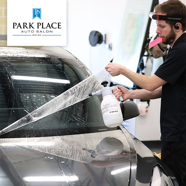 Employee instaling protective shield on a car